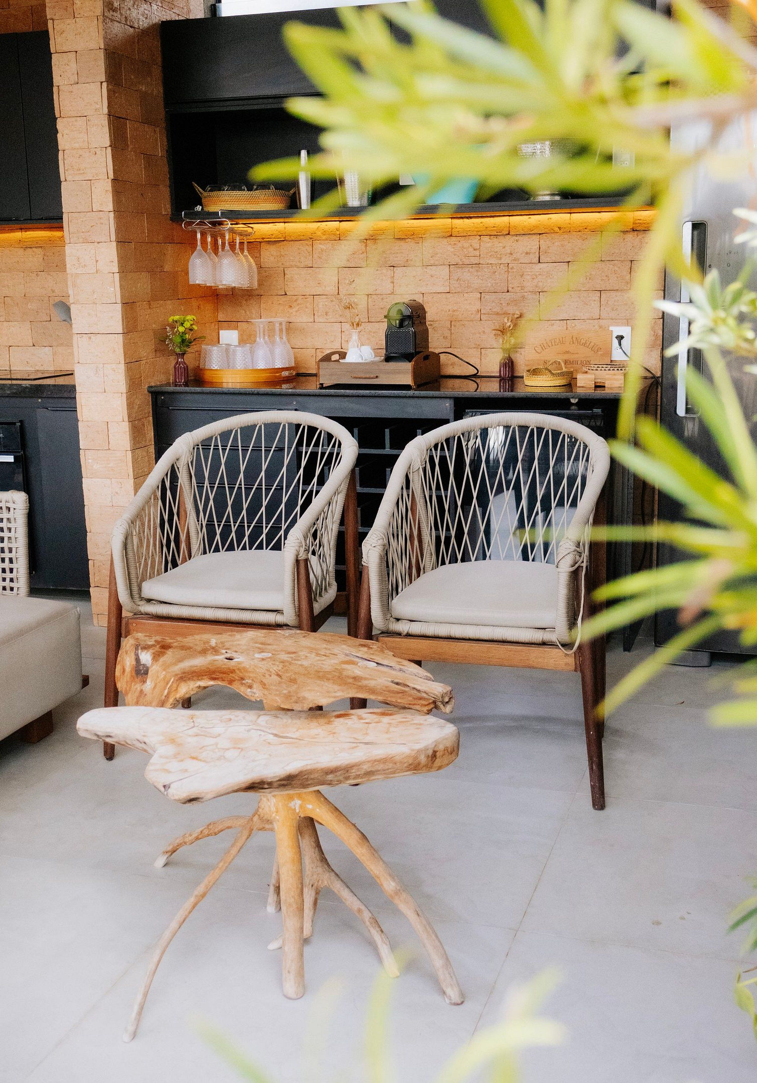 Een rustieke buitenruimte met rieten stoelen en een houten tafel.