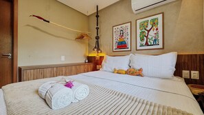 A neatly made bed with white linens, a decorative wall hanging, and two framed artworks. - Casa Deslumbrante a 3min a pe do mar (Sao Miguel dos Milagres)