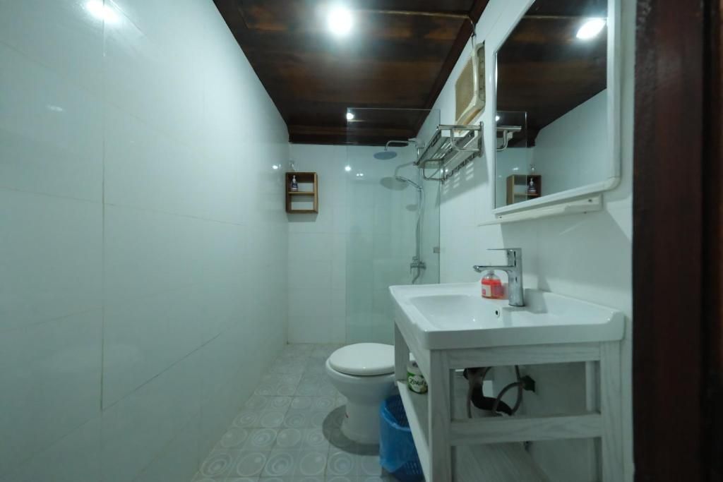 A small bathroom with a toilet, sink, and shower.