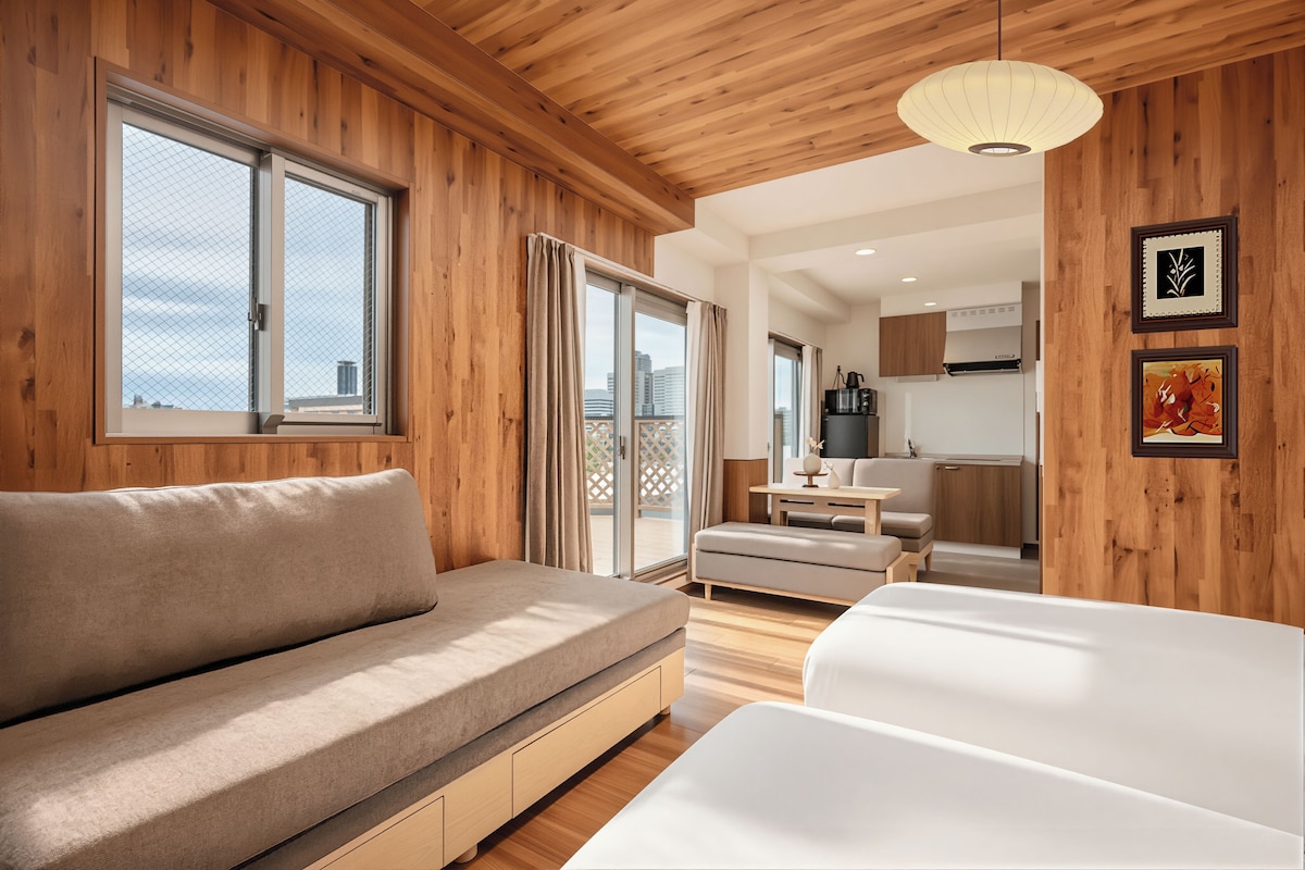 A modern interior with a wooden ceiling, a sofa, a dining table, and a kitchen area.