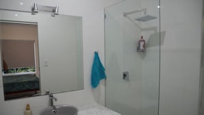 Ein Badezimmer mit Waschbecken, Spiegel und Duschkabine.
