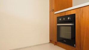 Cuina amb forn negre i armaris de fusta.