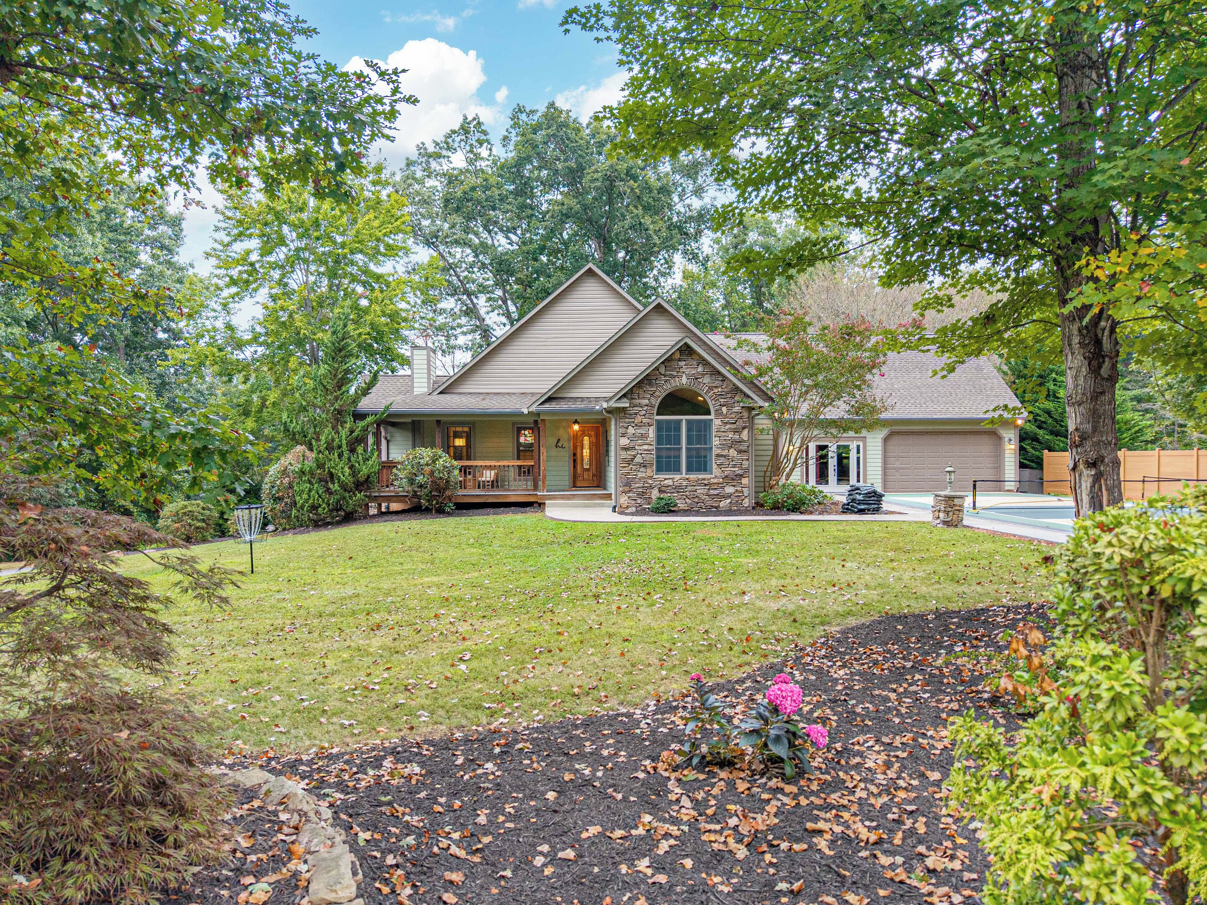 A single-story house with a stone facade, a front porch, and a garage.