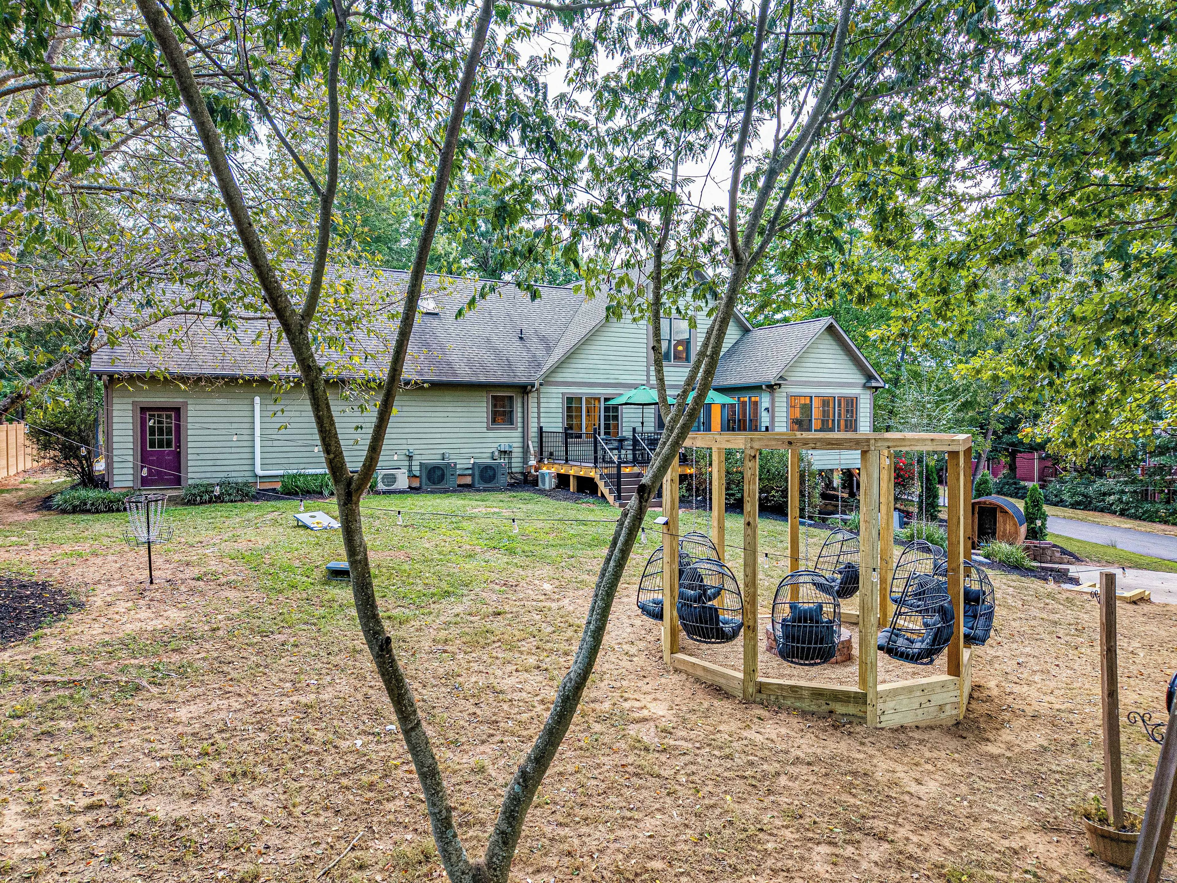A residential property with a house, a swing set, and a fenced yard.