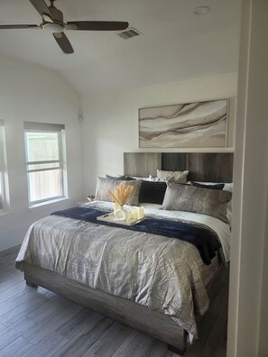 A bedroom with a bed, a ceiling fan, a window, and a painting on the wall. - Luxury 3BR/3.5BA Sanctuary Near Downtown -Garage - EV Charger -Generator (Houston)
