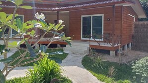 Una casa de madera con un porche y un pequeño jardín.