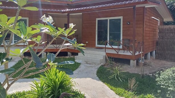 Ein Holzhaus mit Veranda und kleinem Garten.