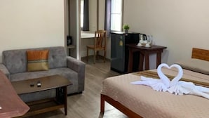Ein Hotelzimmer mit einem Bett, einer Couch, einem kleinen Tisch und einem Schreibtisch.
