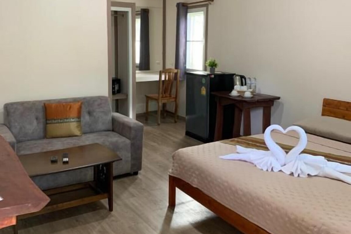 Ein Hotelzimmer mit einem Bett, einer Couch, einem kleinen Tisch und einem Schreibtisch.