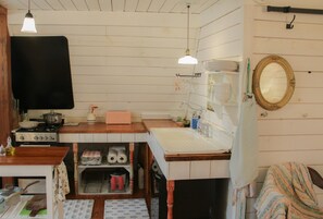 A compact kitchen with a stove, sink, and a small dining area. - Romantic barn loft near buffalo national river (Saint Joe)