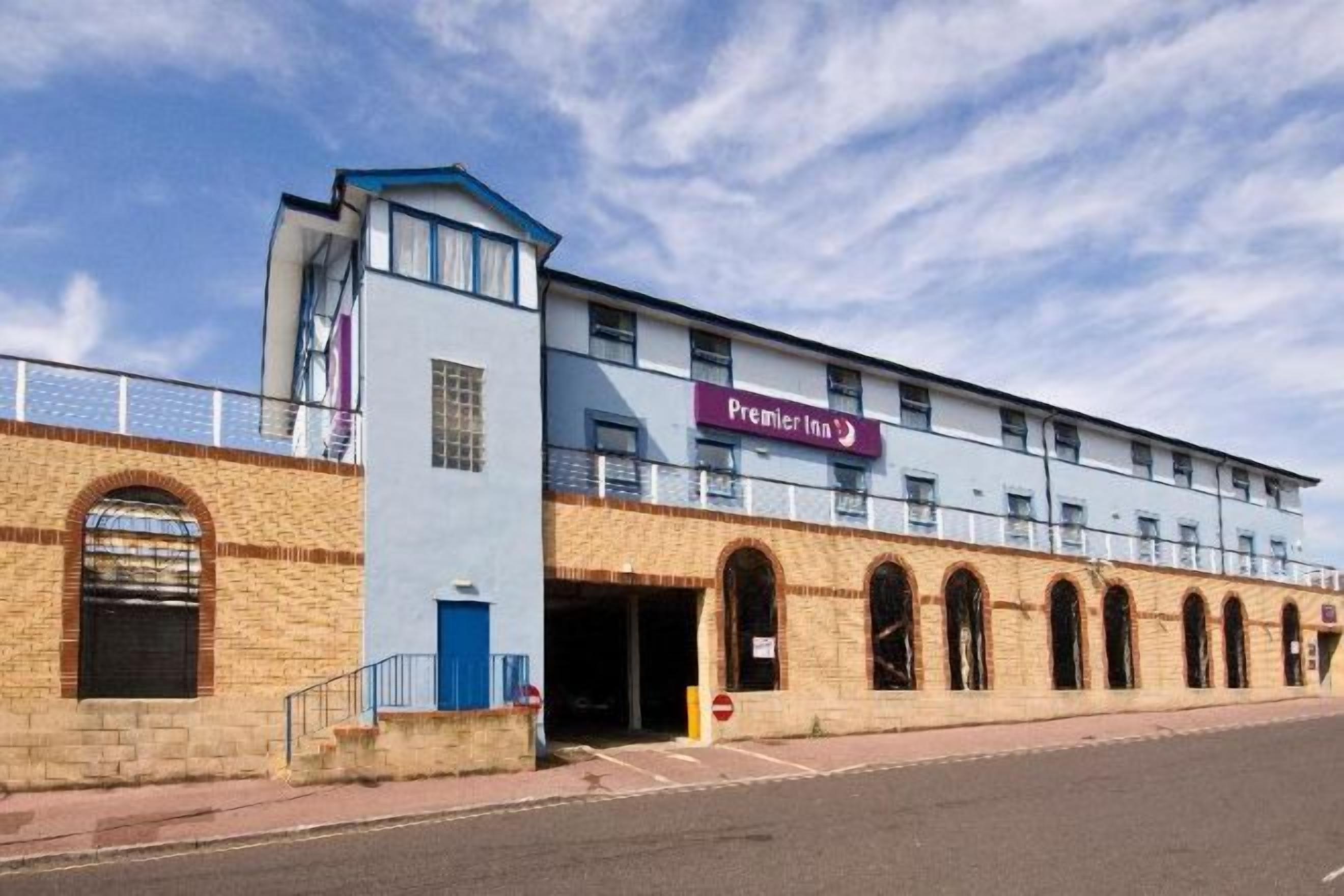 A hotel with a prominent 'Premier Inn' sign, a brick facade, and a flat roof.