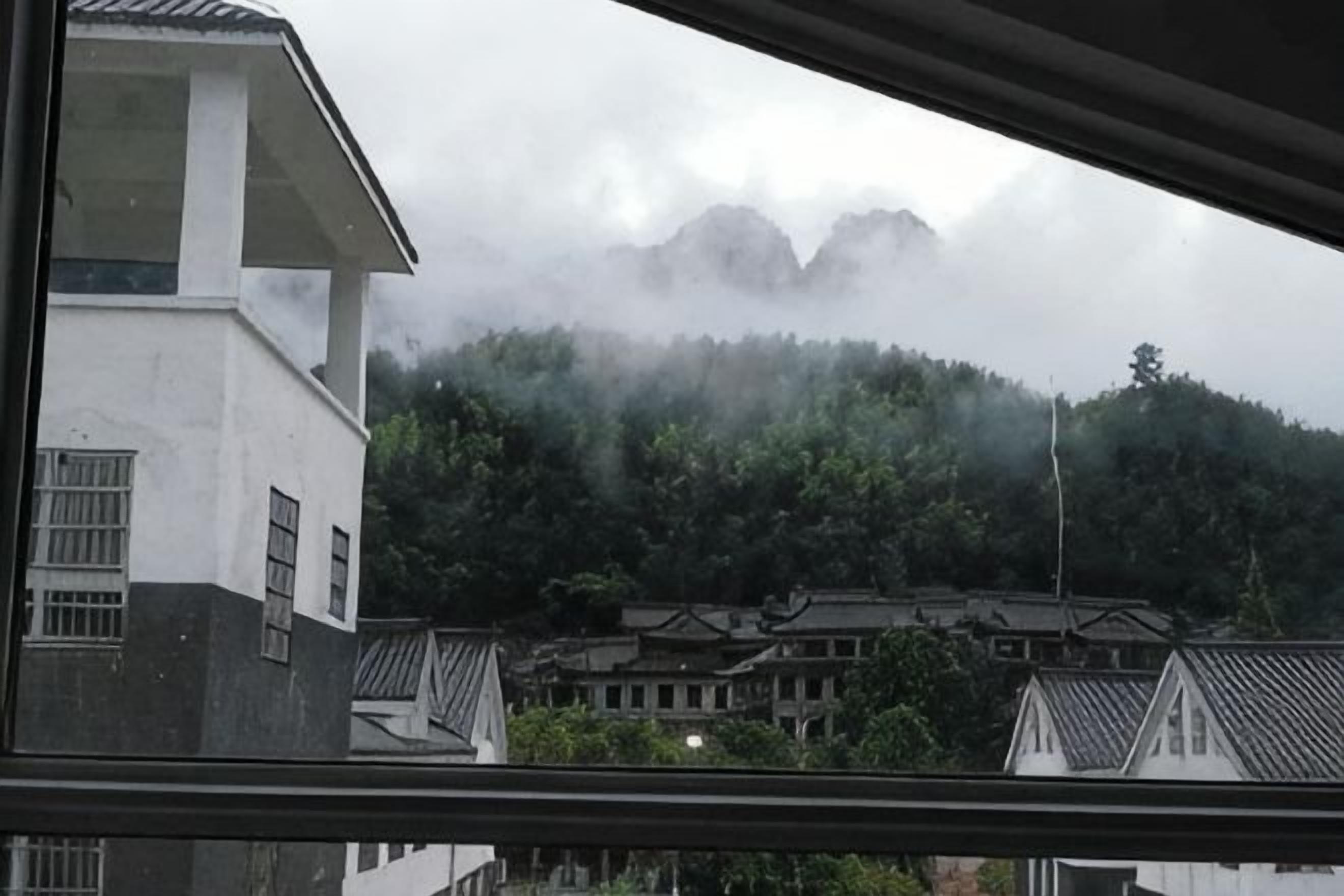 A view of a building with a traditional roof and a mountain in the background.