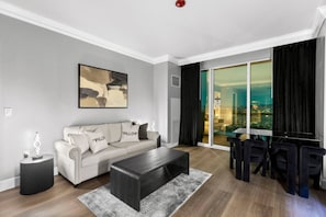 Un salon moderne comprenant un canapé, une table basse et un coin repas avec des chaises.