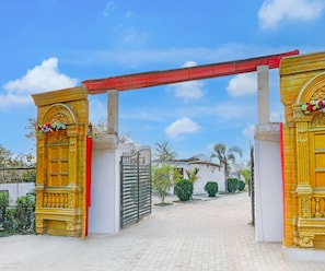 A gated entrance with ornate golden doors and a red roof. - Classic Grand Jvi Resort & Marriage Lawn (Faizabad)