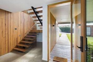 A wooden staircase leading to a modern interior space. - SouthWind your premier escape destination in Merimbula (Merimbula)