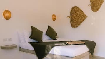 A bed with a wooden headboard, a bedside table, and a wall-mounted light fixture.