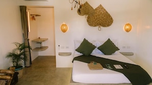 A bedroom with a bed, bedside tables, a hanging basket, and a small table with a plant. - SAMPA El Nido (El Nido)