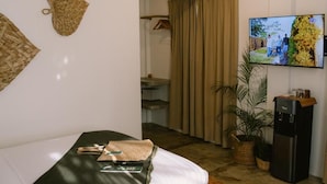 A hotel room with a bed, a television, a water dispenser, and a potted plant. - SAMPA El Nido (El Nido)