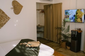 A hotel room with a bed, a television, a water dispenser, and a potted plant. - SAMPA El Nido (El Nido)