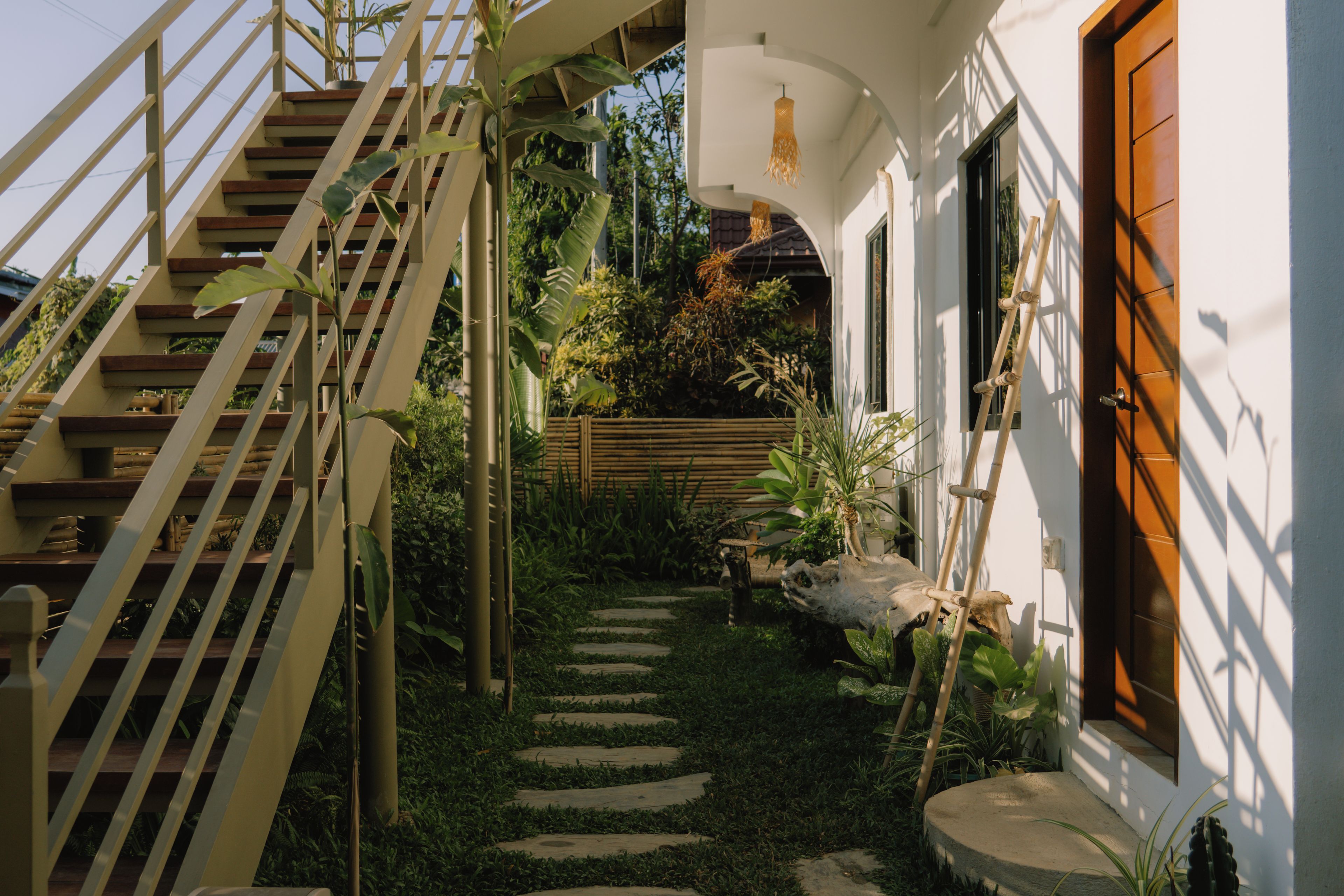 A staircase leading to a house with a garden path.