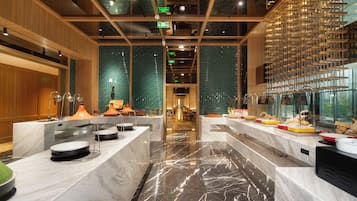 Un moderno vestíbulo de hotel con suelo de mármol, paneles de madera y una zona de estar central.
