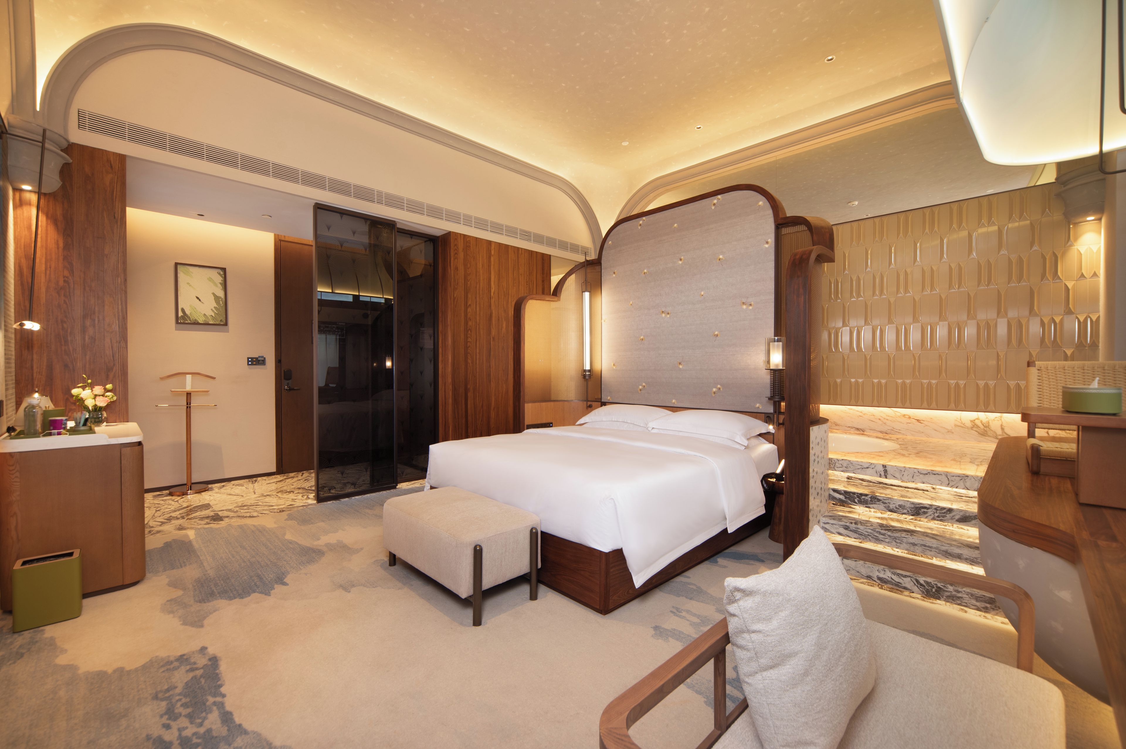 Une chambre d’hôtel spacieuse, dotée d’un grand lit, d’un coin salon et d’une salle de bain.