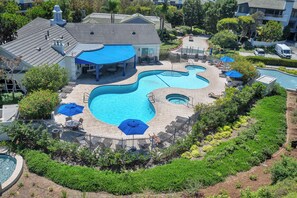 Ein Poolbereich mit mehreren Pools, Liegestühlen und Sonnenschirmen.