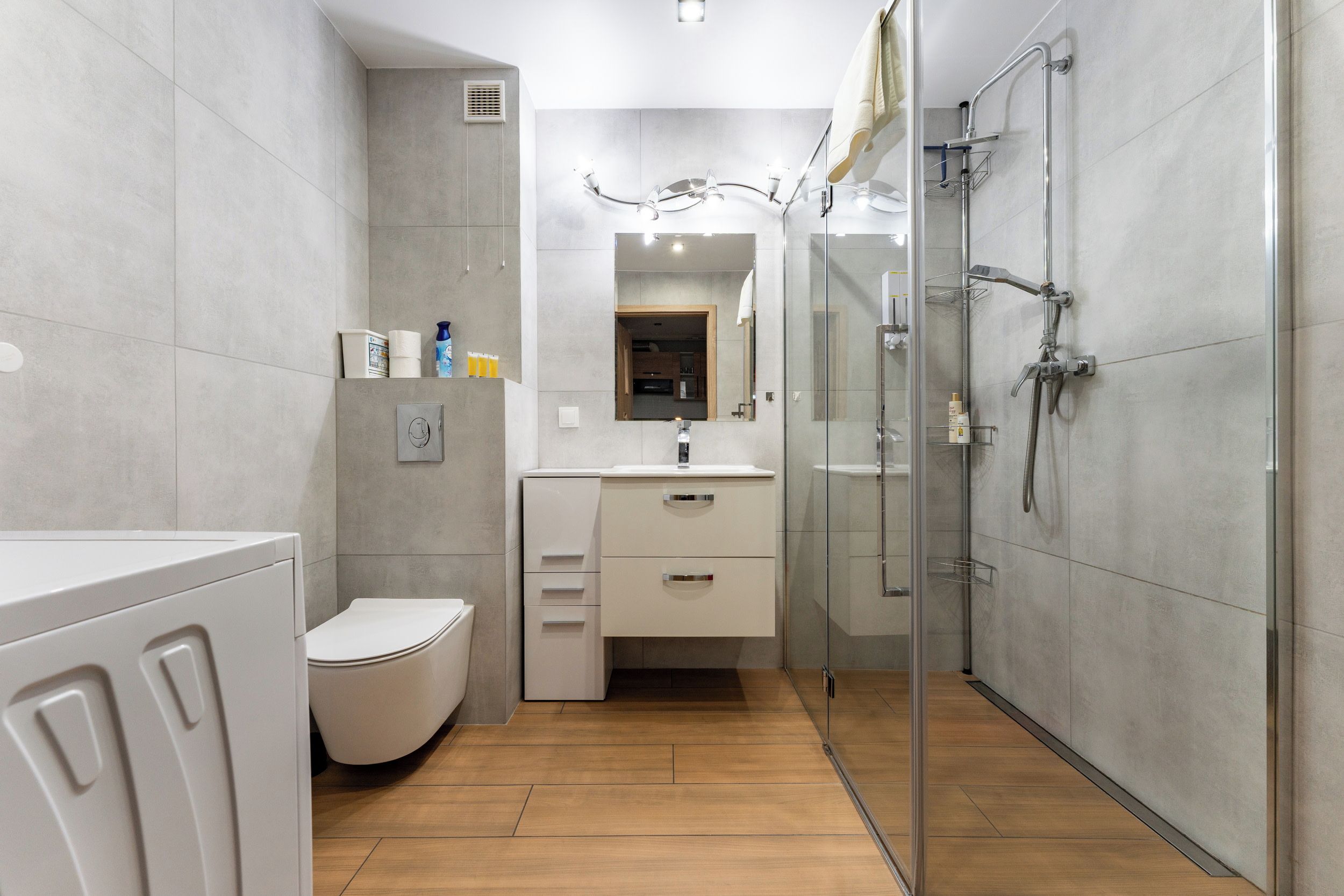 A modern bathroom with a toilet, sink, and glass-enclosed shower.