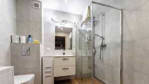 A modern bathroom with a toilet, sink, and shower. - Gdańsk Koprowskiego Apartment #18 (Gdańsk)