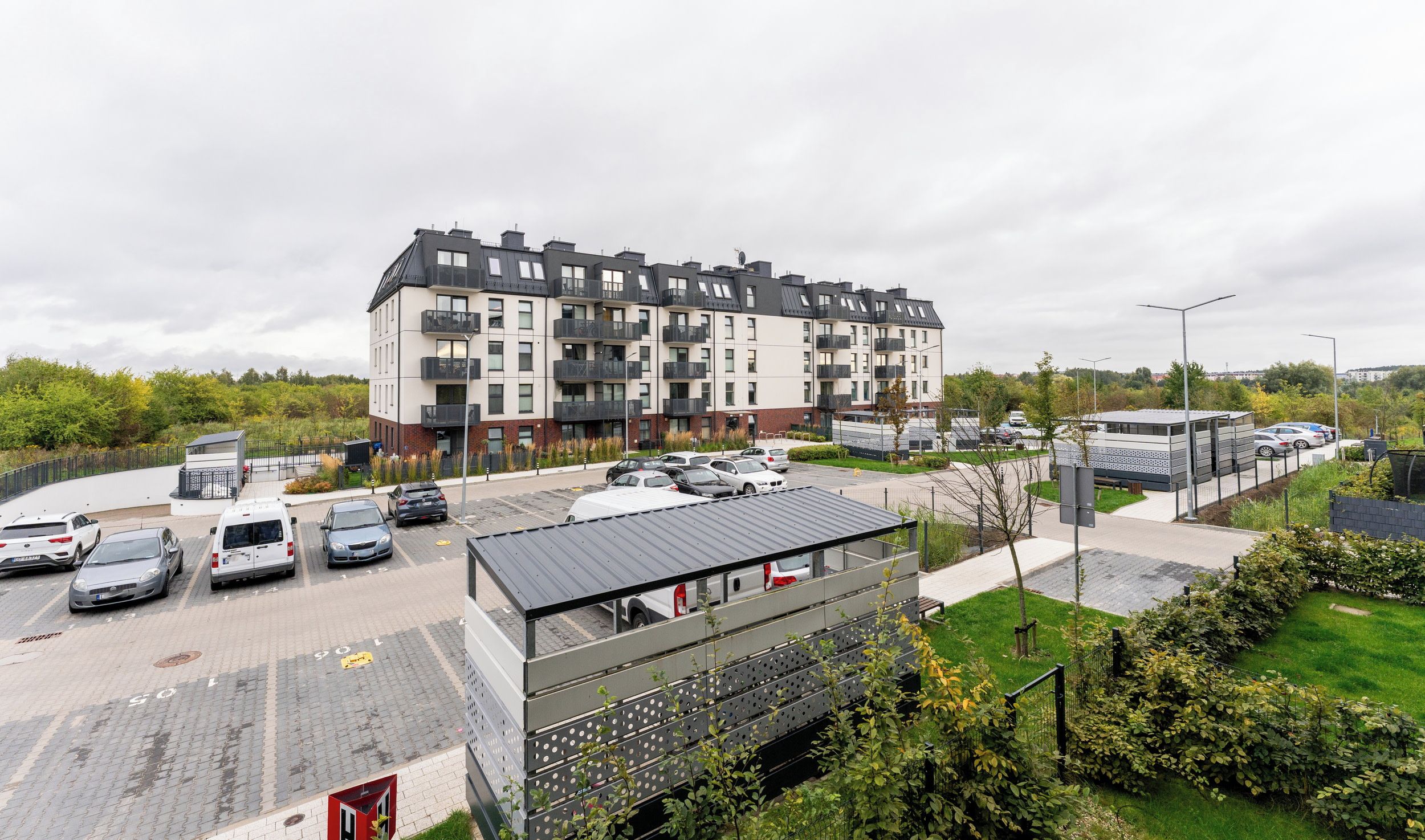 A multi-story residential building with a parking lot in front.