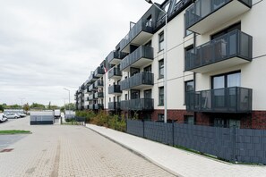 A modern multi-story residential building with balconies and a paved driveway. - Gdańsk Koprowskiego Apartment #34 (Gdańsk)