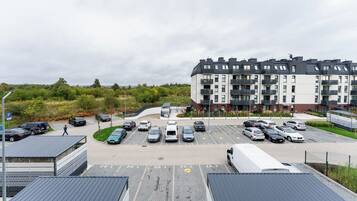 A multi-story residential building with a parking lot in front.