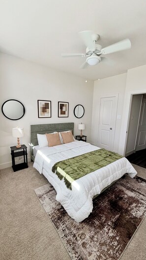 A bedroom with a bed, a ceiling fan, a green throw blanket, and a rug. - Modern Cozy Retreat Minutes From Downtown Houston (Houston)
