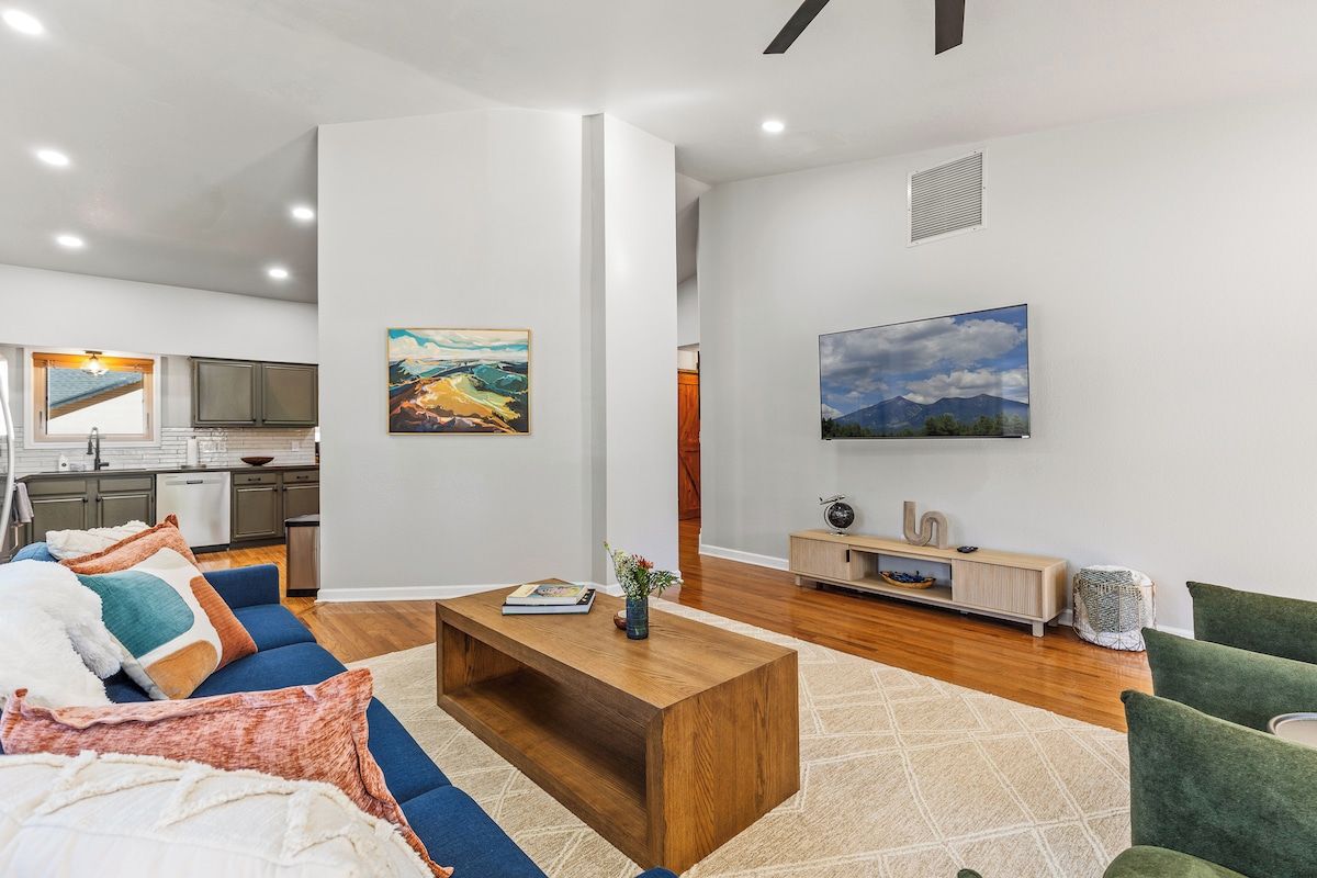 A modern living room with a sofa, coffee table, and artwork on the walls.