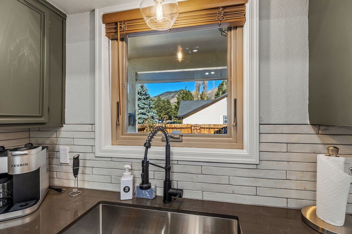 A kitchen with a built-in window, a coffee maker, and a paper towel holder.
