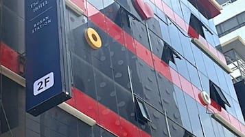 Un edificio moderno con ventanas de vidrio reflectante y un letrero de hotel destacado.