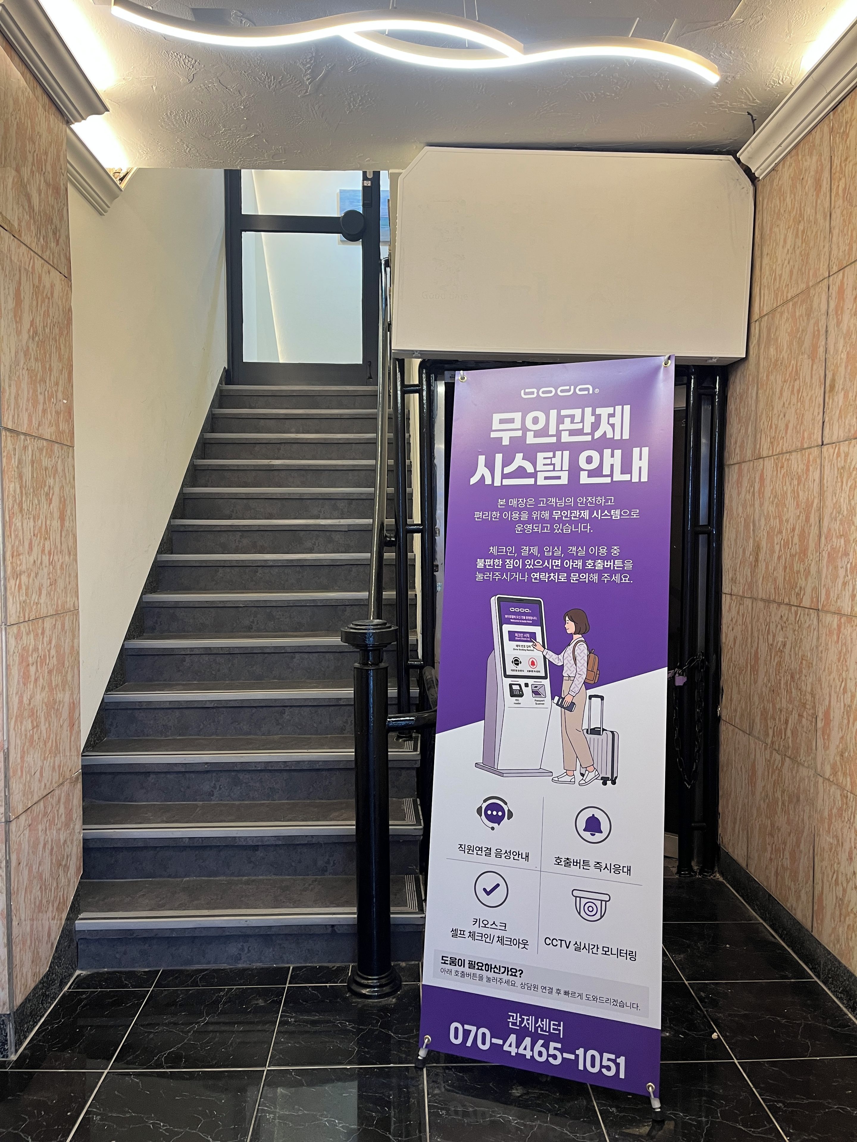 Una escalera con un cartel informativo morado y un número de contacto.