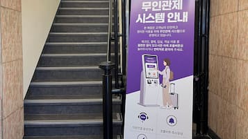 Una escalera con un cartel informativo morado y un número de contacto.