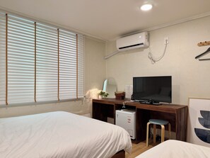 A hotel room with two beds, a desk with a television, a small refrigerator, and an air conditioning unit. - The Shim Hotel Busan Station (Busan)