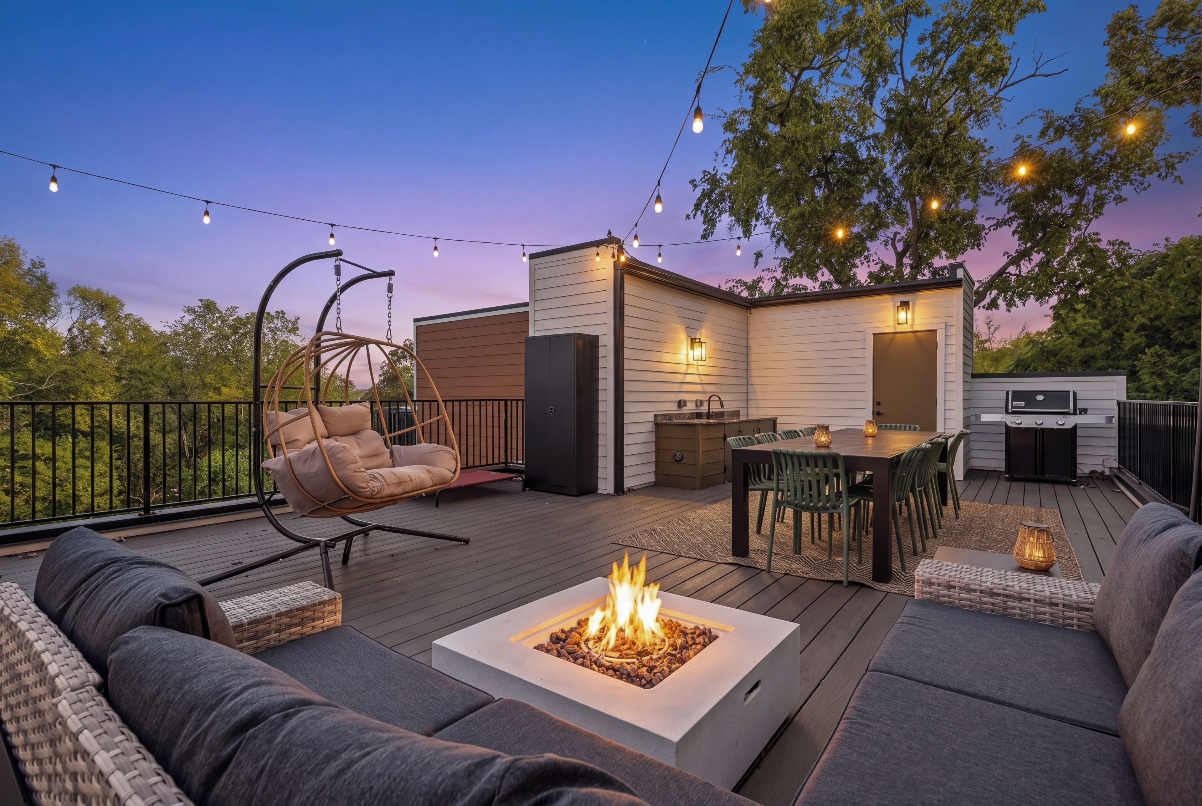 An outdoor deck with a fire pit, seating, and a grill area.