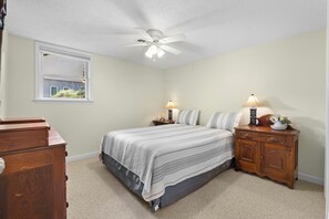 A bedroom with a bed, nightstands, a dresser, a ceiling fan, and a window with blinds. - Hillview Lakefront Retreat w/ Private Pier (Lexington)