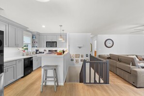 A modern kitchen with grey cabinets, a central island, and stainless steel appliances. - Hillview Lakefront Retreat w/ Private Pier (Lexington)