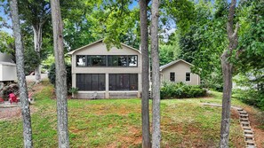 A two-story house with a front porch and a small attached garage. - Hillview Lakefront Retreat w/ Private Pier (Lexington)