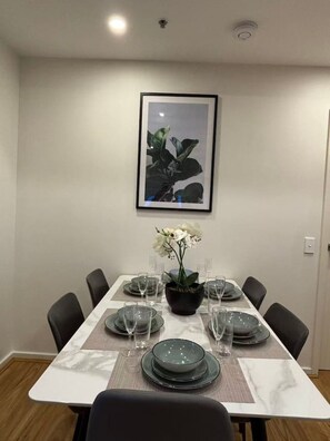 A dining table set with plates, glasses, and a centerpiece. - Zetland 3BR·Sleeps 7 | Parking · 4min to Central (Zetland)