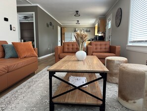 A modern living room with a wooden coffee table, leather sofas, and a decorative vase. - Cozy Cabin/ORV/Fishing/Fire Pit/Dog Friendly (Irons)