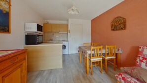 A compact living space with a kitchenette, a dining area, and a sofa. - Apartment for 2 near Les Rousses center (Les Rousses)