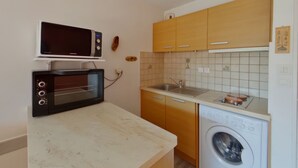 A compact kitchen with a microwave, oven, sink, and washing machine. - Apartment for 2 near Les Rousses center (Les Rousses)