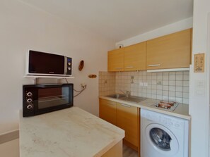 A compact kitchen with a microwave, oven, sink, and washing machine. - Apartment for 2 near Les Rousses center (Les Rousses)