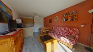 A living room with a sofa, a coffee table, and a television on a wooden cabinet. - Apartment for 2 near Les Rousses center (Les Rousses)