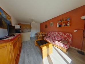 A living room with a sofa, a coffee table, and a television on a wooden cabinet. - Apartment for 2 near Les Rousses center (Les Rousses)